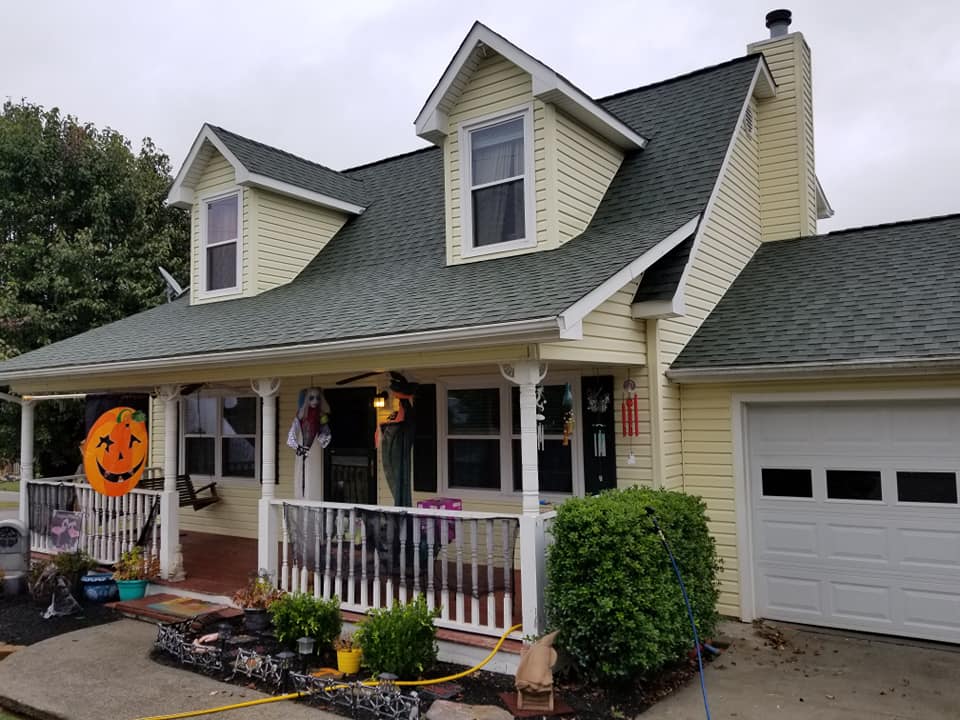 Yellow vinyl home with pressure washing hose ready for exterior cleaning